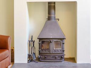 a stove in the corner of a room at The Coach House - Uk35246 in Llanfyrnach