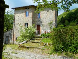 een oud stenen huis met een trap ervoor bij Dreamy Cottage in Trebbio with Swimming Pool in Pescaglia