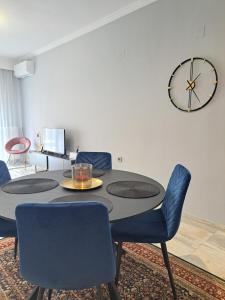 a dining room with a table and chairs and a clock at Twins Apartments 2 in Serres +46 photos