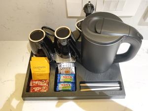 a tray with a coffee pot and some food at The Bansara Royal in Kātoya