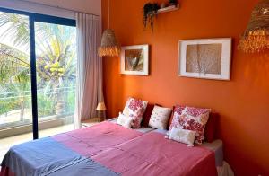 a bedroom with an orange wall with a bed and a window at Penthouse - Sea view, Private roof top pool, Golf in Roches Noires