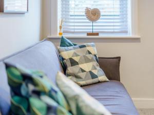 a blue couch with pillows in a living room at 6 Eastgate -Uk34289 in Andover