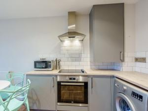 a kitchen with a stove top oven next to a microwave at 6 Eastgate -Uk34289 in Andover