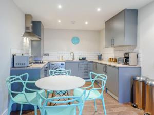 a kitchen with a table and blue chairs at 6 Eastgate -Uk34289 in Andover +8 photos