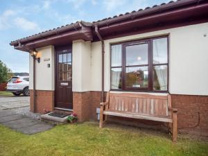 a house with a bench in front of it at Dalfaber View-Ukc5054 in Aviemore