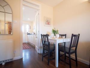 a dining room with a white table and chairs at Dalfaber View-Ukc5054 in Aviemore