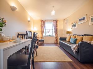 a living room with a couch and a table at Dalfaber View-Ukc5054 in Aviemore