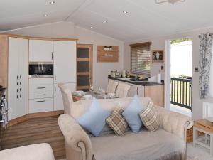 a living room with a couch and a kitchen at Herdwick Lodge - Uk3426 in Newton on the Moor