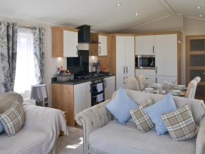 a living room with a couch and a kitchen at Herdwick Lodge - Uk3426 in Newton on the Moor