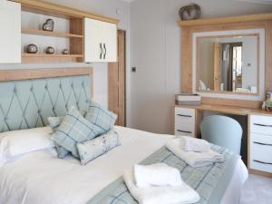 a bedroom with a bed with a desk and a mirror at Herdwick Lodge - Uk3426 in Newton on the Moor