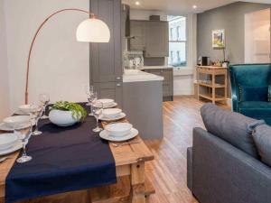 a dining room table with wine glasses and a couch at Broad Street in Bath
