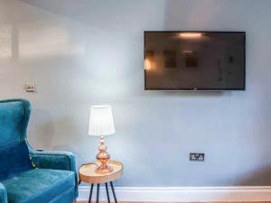 a living room with a blue couch and a table with a lamp at Broad Street in Bath