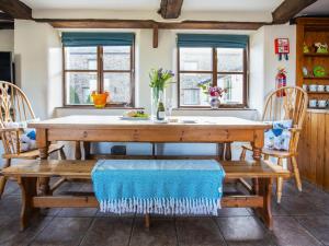 a dining room with a wooden table and benches at Jasmine Cottage - Ukc4694 in Kilkhampton