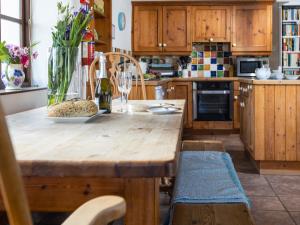 a kitchen with a wooden table with a vase of flowers at Jasmine Cottage - Ukc4694 in Kilkhampton +17 photos