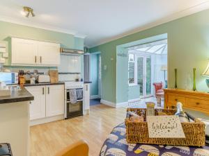 a kitchen and living room with white cabinets at Ivy Cottage - Uk35243 in Llanfyrnach