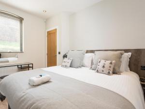 a white bedroom with a large white bed with pillows at 1 Monkbar Mews - Uk2690 in York