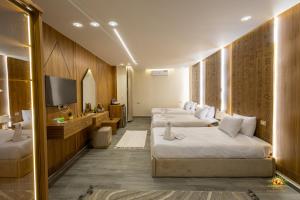 a hotel room with three beds and a television at Khofo pyramids view inn in Cairo