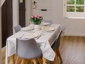 a dining room table with chairs and flowers on it at Corner Cottage - Ukc4962 in Tawstock