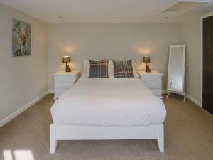 a bedroom with a large white bed with two night stands at Corner Cottage - Ukc4962 in Tawstock +25 photos