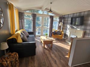 a living room with a couch and a table at Barnston Lodge in Newton on the Moor