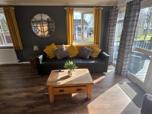 a living room with a couch and a coffee table at Barnston Lodge in Newton on the Moor +9 photos