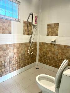 a bathroom with a shower and a toilet at สายป่านอาพาร์ทเม้นท์ in Ban Bung Sam Phan Nok +66 photos
