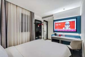 a hotel room with a bed and a flat screen tv at Ibis Beijing Tiananmen Square in Beijing