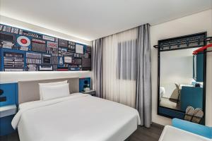 a hotel room with a bed and a mirror at Ibis Beijing Tiananmen Square in Beijing