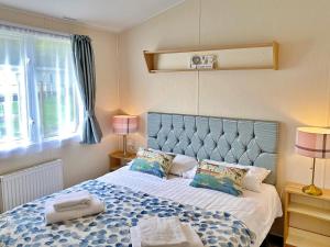 a bedroom with a large bed with two pillows at Flamingo's Rest - Uk3348 in Newton on the Moor