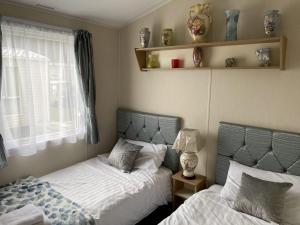 a bedroom with two beds and a window at Flamingo's Rest - Uk3348 in Newton on the Moor +2 photos