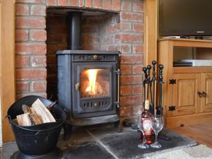 a brick fireplace with a stove in a room at Bevan House in Llansaintfraed in Elvel