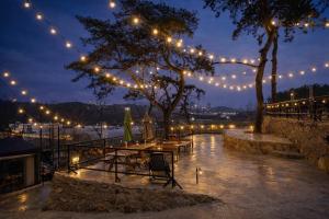 a patio with lights and a table and a tree at Busan Mandiga Pool Villa in Busan