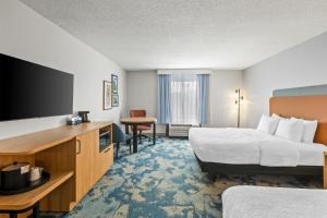 a hotel room with two beds and a flat screen tv at Hampton Inn Carrollton in Carrollton