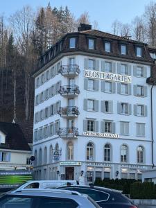 a white building with cars parked in front of it at Klostergarten in Einsiedeln