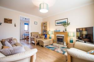 a living room with two couches and a fireplace at Beach House Walk - Crail - Home from Home in Crail