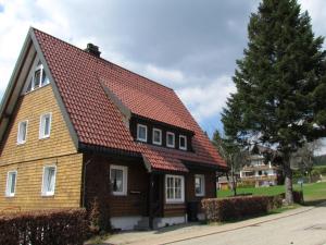 ein braunes Haus mit rotem Dach in der Unterkunft Hirschenhäusle in Sankt Märgen