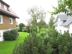 ein Hof eines Hauses mit Bäumen und Sträuchern in der Unterkunft Hirschenhäusle in Sankt Märgen