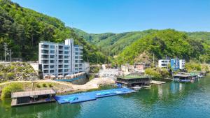 a river with buildings and boats in the water at Gapyeong Laputa Resort in Gapyeong