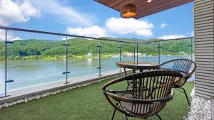 a chair sitting on a balcony with a view of the water at Gapyeong Laputa Resort in Gapyeong