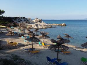 a group of chairs and umbrellas on a beach at Haus Despina in Sarti