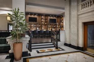 a lobby with a bar with black stools at Hilton Pennywell St Louis at the Arch in Saint Louis