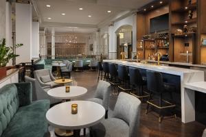 a restaurant with tables and chairs and a bar at Hilton Pennywell St Louis at the Arch in Saint Louis
