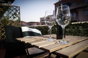 due bicchieri da vino seduti sopra un tavolo di legno di RomeTown B&B a Roma