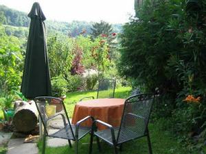 una mesa con sillas y una sombrilla en el jardín en Ferienwohnung Anne Rüdlin, en Badenweiler
