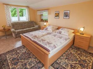a bedroom with a large bed and a couch at Holiday home near the ski area in Kurort Steinbach-Hallenberg