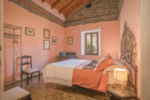 a bedroom with a bed and a chair and a window at Agriturismo Tripala in Minucciano +88 photos