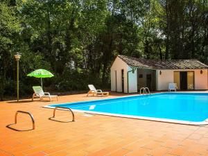 basen z 2 krzesłami i parasolem w obiekcie Belvilla by OYO Holiday Home with Pool w mieście Canneto