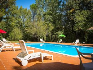 basen z krzesłami i stołami w obiekcie Belvilla by OYO Holiday Home with Pool w mieście Canneto