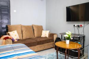 a living room with a couch and a table at Ziwa View studio Apartments in Goat Island