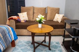 a living room with a table with flowers on it at Ziwa View studio Apartments in Goat Island